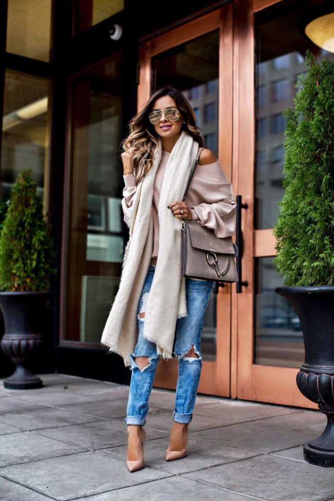 fashion blogger mia mia mine wearing a pink sweater and ripped jeans