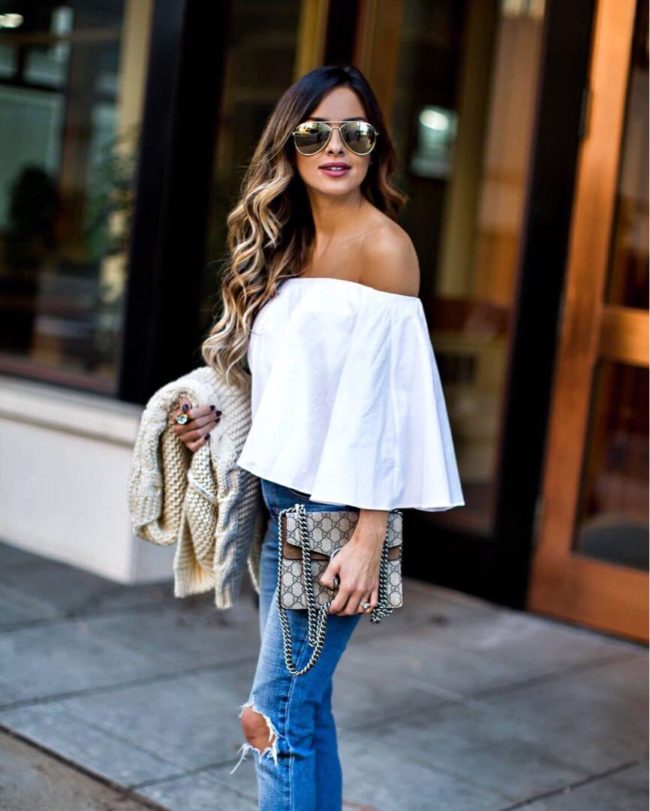 Mia mia mine wearing a white off-the-shoulder top and gold aviator sunglasses from shopbop
