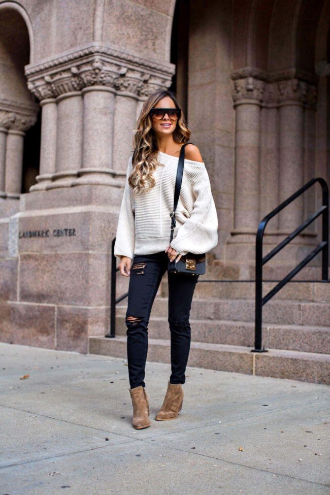 fashion blogger mia mia mine wearing an off-the-shoulder ivory sweater and black ripped topshop jeans from nordstrom