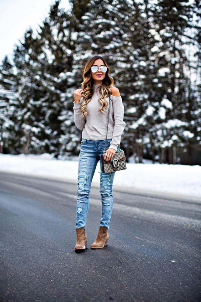 fashion blogger mia mia mine wearing a cold-shoulder sweater and ripped jeans from express
