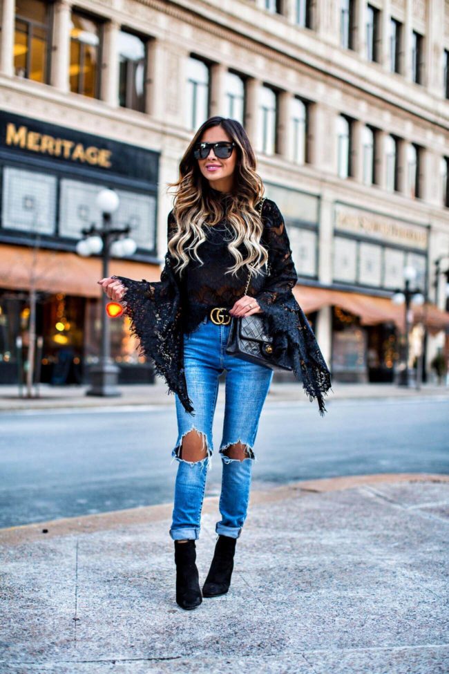 fashion blogger mia mia mine wearing a black lace bell sleeve top by minkpink and ripped levi's jeans