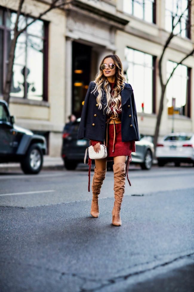fashion blogger mia mia mine wearing a lace-up sweater dress by lovers + friends from revolve and steve madden over-the-knee boots