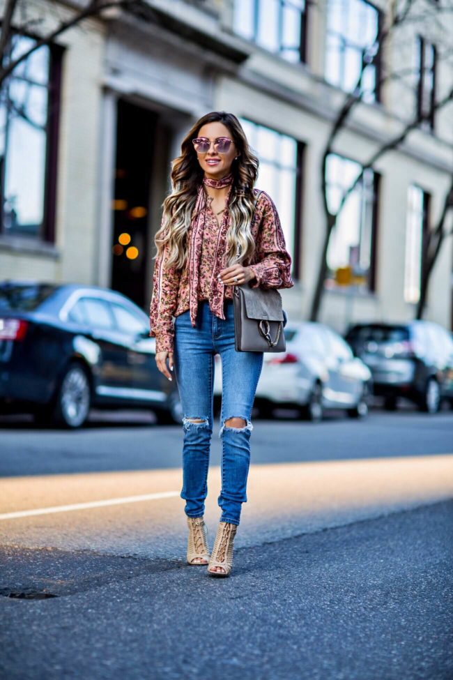 fashion blogger mia mia mine wearing a pink floral print top and distressed jeans by rollas