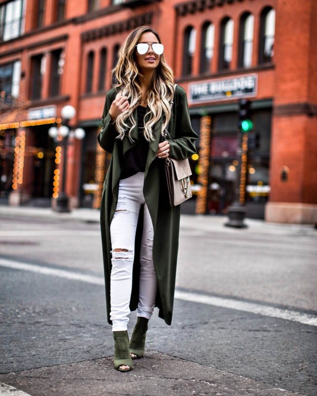 fashion blogger mia mia mine wearing white distressed jeans and a green coat