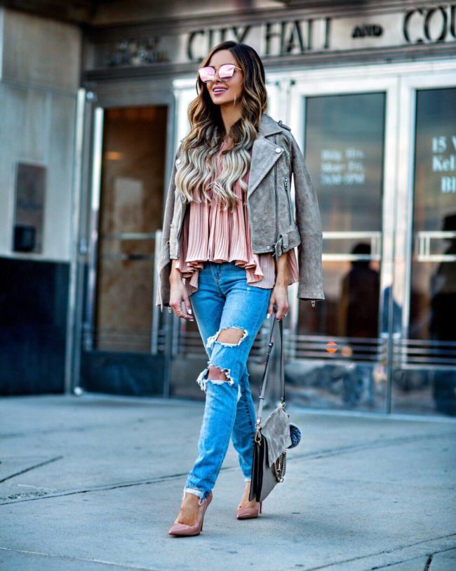 fashion blogger mia mia mine wearing a pink top and suede moto jacket from revolve