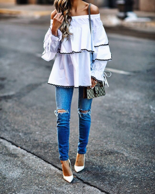 fashion blogger mia mia mine wearing a white ruffle top and white heels