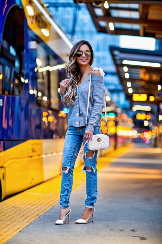 fashion blogger mia mia mine wearing a shoulder-tie gray cardigan and ripped jeans from revolve