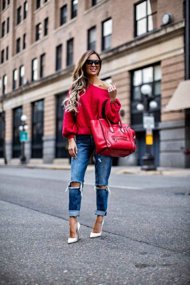 mn fashion blogger mia mia mine wearing a red off-the-shoulder sweatshirt and grlfrnd denim revolve