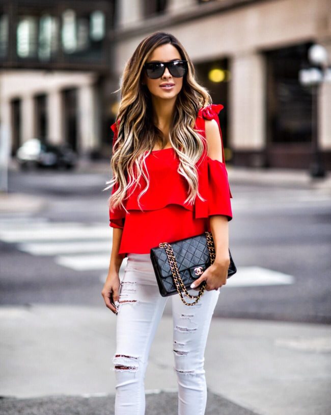 fashion blogger mia mia mine wearing a red bow sleeve top and a chanel 2.55 bag