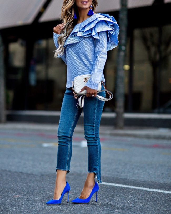 fashion blogger mia mia mine wearing a blue striped statement top and step hem jeans from shopbop