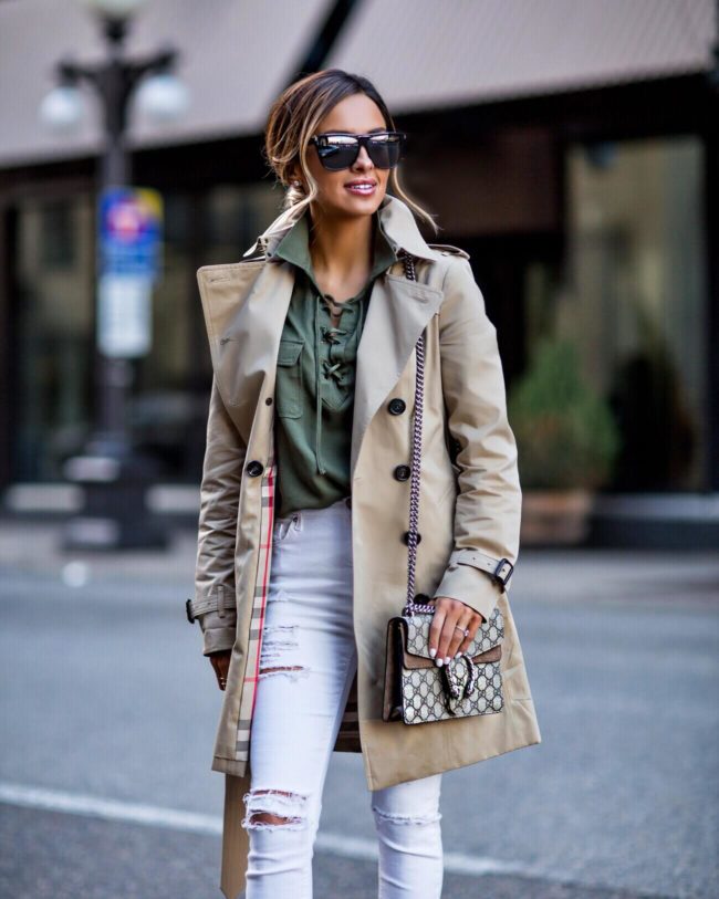 fashion blogger mia mia mine wearing a lace-up green top and a burberry jacket