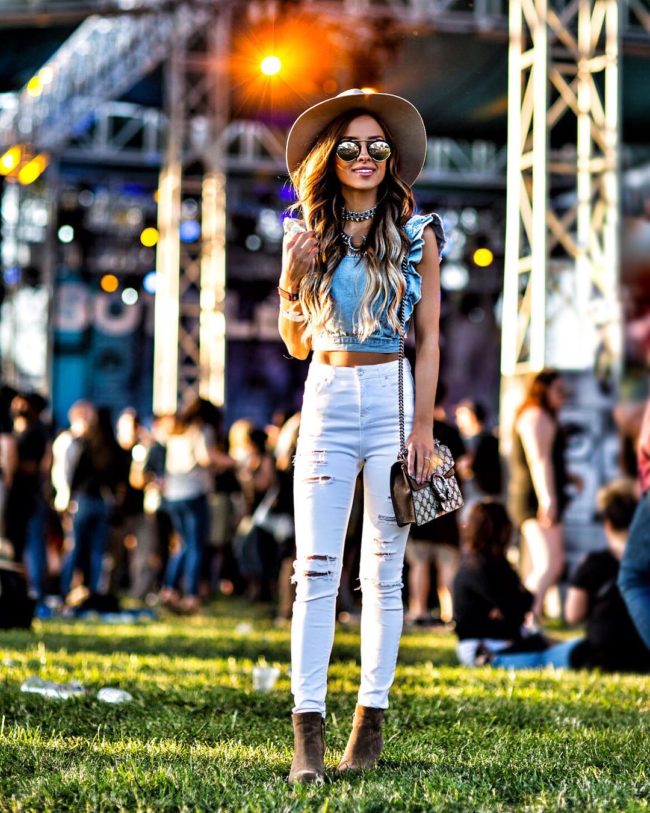 fashion blogger mia mia mine wearing a crop top and hat at bottlerock napa