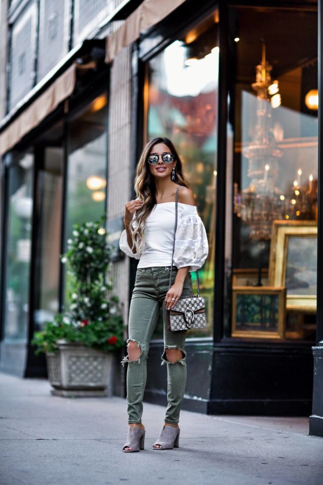 fashion blogger mia mia mine wearing a free people white top and moss green ripped jeans with a gucci dionysus bag