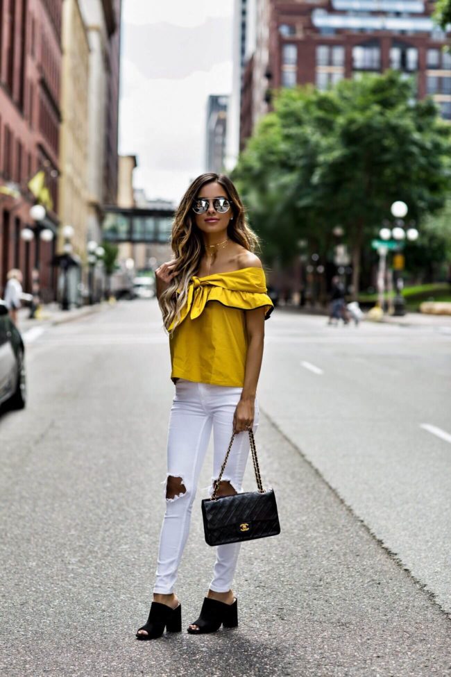 fashion blogger mia mia mine wearing free people white denim from revolve and black suede slides