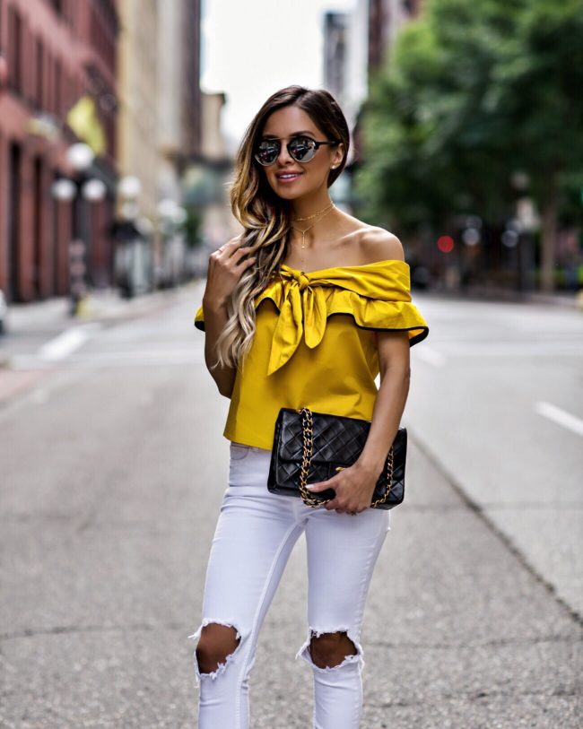 fashion blogger mia mia mine wearing a yellow top from revolve and a chanel bag