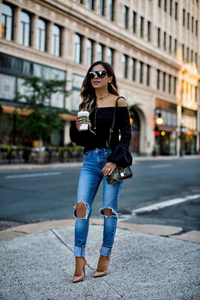 fashion blogger mia mia mine wearing a black bell sleeve top from asos and levis jeans
