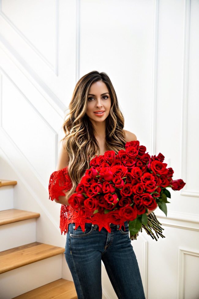 beauty blogger mia mia mine wearing a red lace off-the-shoulder top from nordstrom