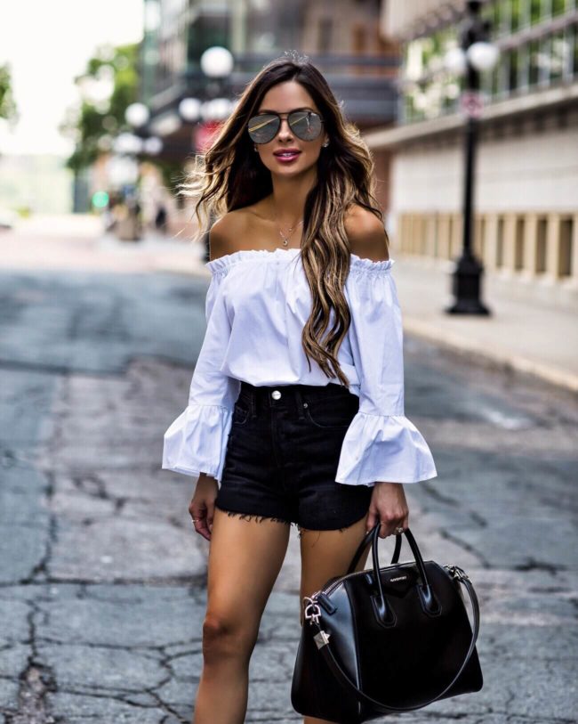fashion blogger mia mia mine wearing a white off-the-shoulder top and black denim shorts from nordstrom and a givenchy antigona bag