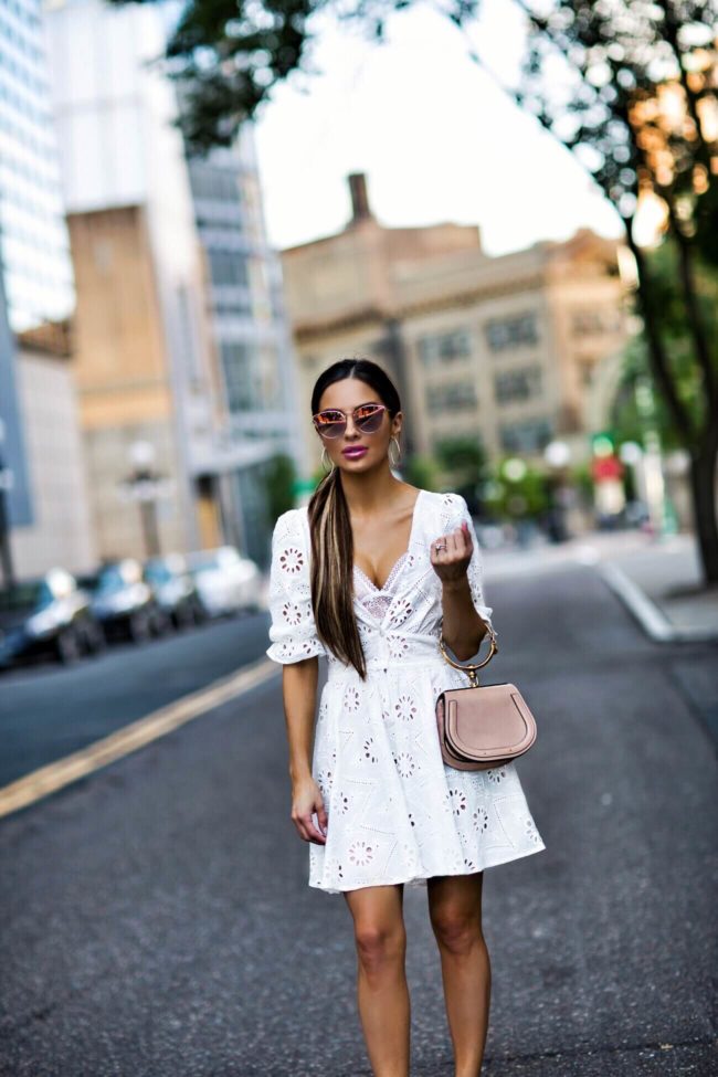 fashion blogger mia mia mine wearing a white eyelet dress from revolve and pink quay aviator sunglasses