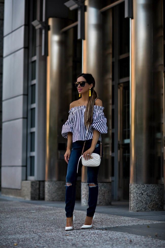 fashion blogger mia mia mine wearing a striped top from revolve and yellow baublebar earrings