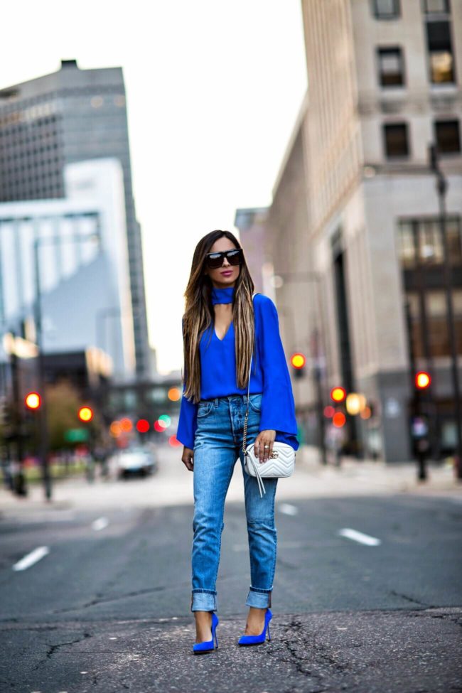 fashion blogger mia mia mine wearing a blue cutout top and levi's jeans