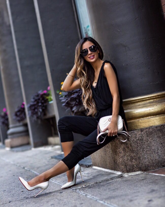 fashion blogger mia mia mine wearing a black jumpsuit in minneapolis