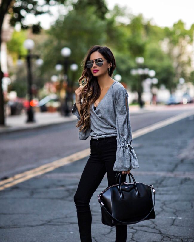 fashion blogger mia mia mine wearing a gray wrap top and a givenchy bag