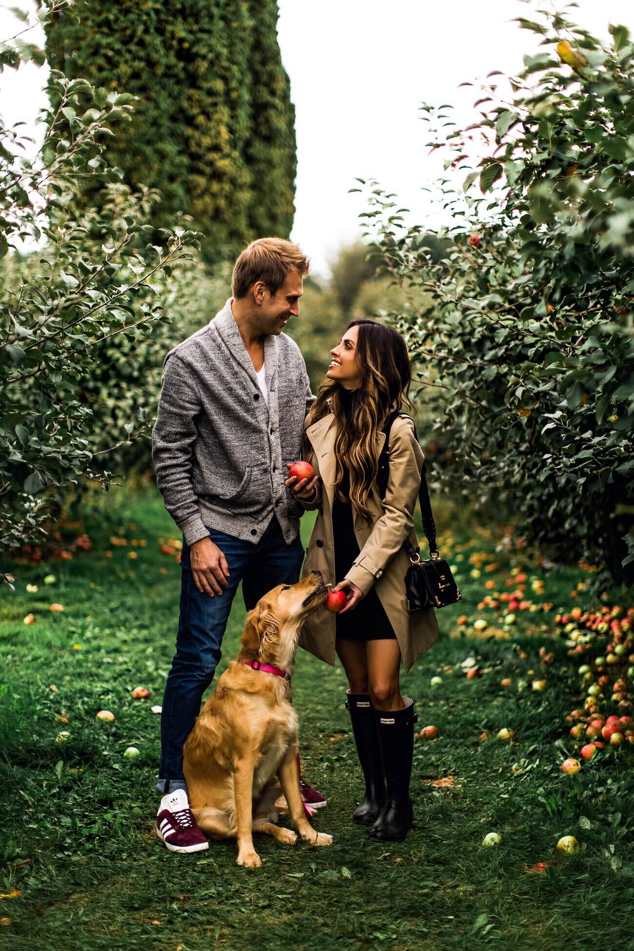 maria vizuete and phil thompson at an apple orchard with golden retriever