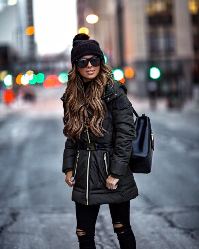 mia mia mine wearing a green winter coat and black beanie