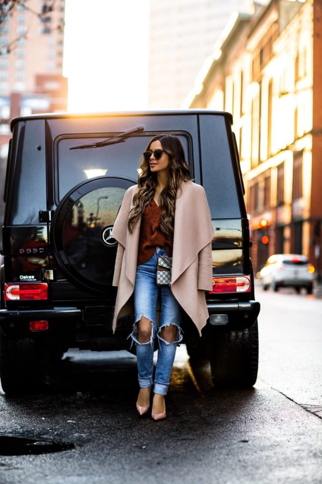 mia mia mine wearing an orange free people sweater and levi's denim