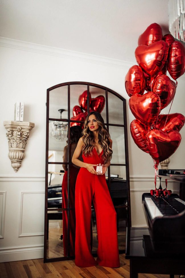 fashion blogger mia mia mine wearing a red jumpsuit from nordstrom and stuart weitzman nudist heels