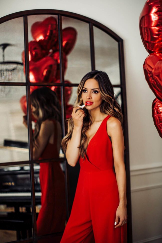fashion blogger mia mia mine wearing a red jumpsuit from nordstrom for valentine's day
