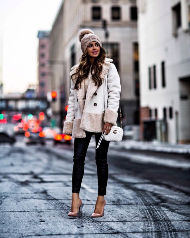 mia mia mine wearing a white shearling jacket and black leather pants