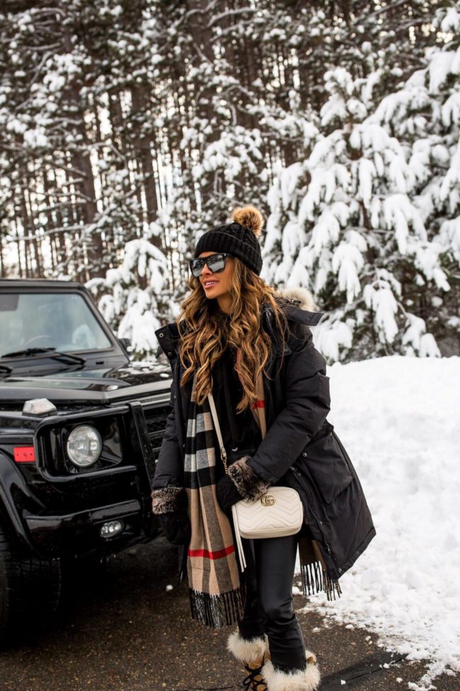 fashion blogger mia mia mine wearing a black parka and gucci marmont bag