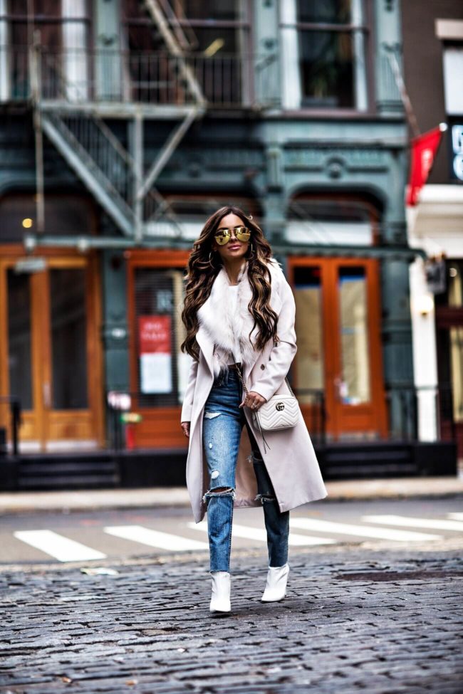 fashion blogger mia mia mine wearing a faux fur winter coat and white steve madden booties