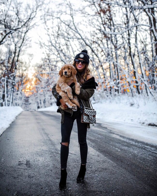 mia mia mine wearing a black beanie with golden retriever puppy
