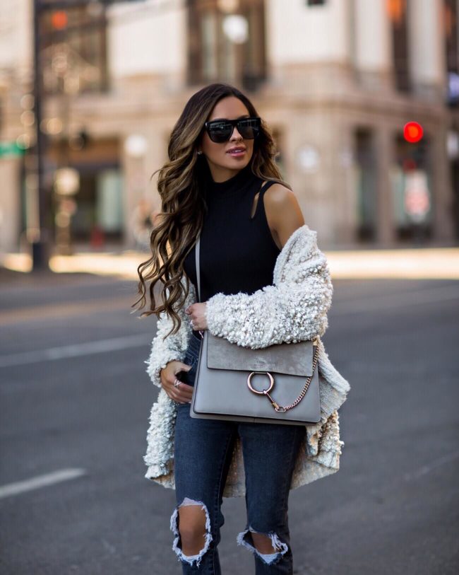 mia mia mine wearing a white cardigan and a chloe faye bag