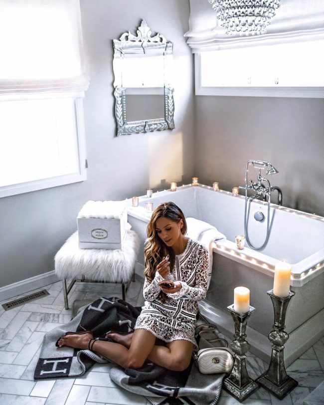 mia mia mine wearing a white lace dress in her bathroom by dxv luxury