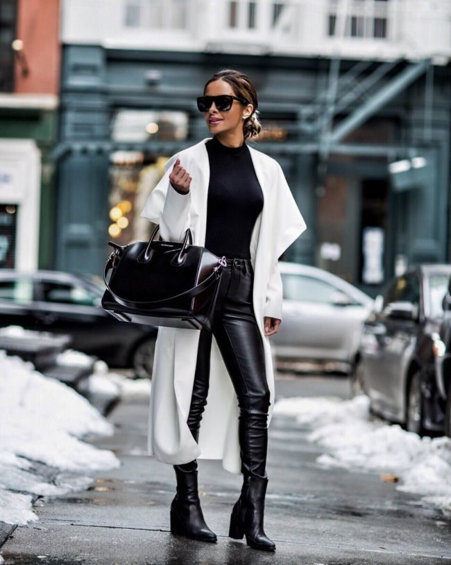 mia mia mine wearing a white coat and black leather leggings