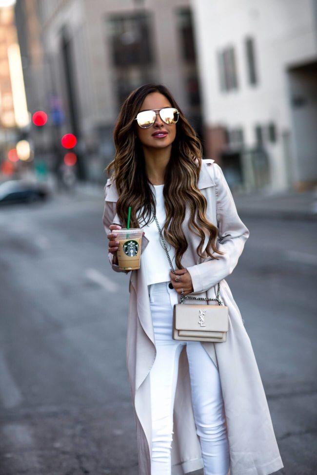 fashion blogger mia mia mine wearing a saint laurent crossbody bag in powder color and a beige trench coat from nordstrom