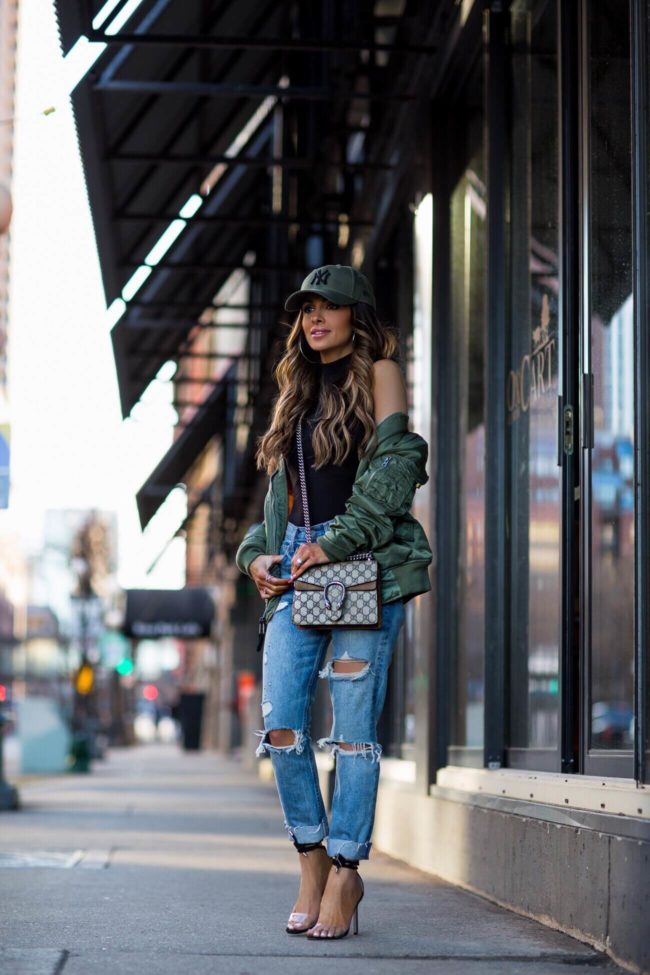 fashion blogger mia mia mine wearing an alpha industries bomber jacket and a gucci mini dionysus bag