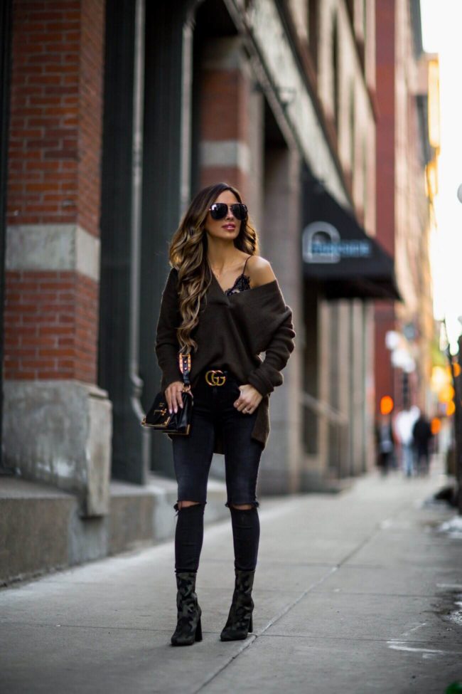 fashion blogger mia mia mine wearing an H&M off-the-shoulder sweater and black denim from revolve