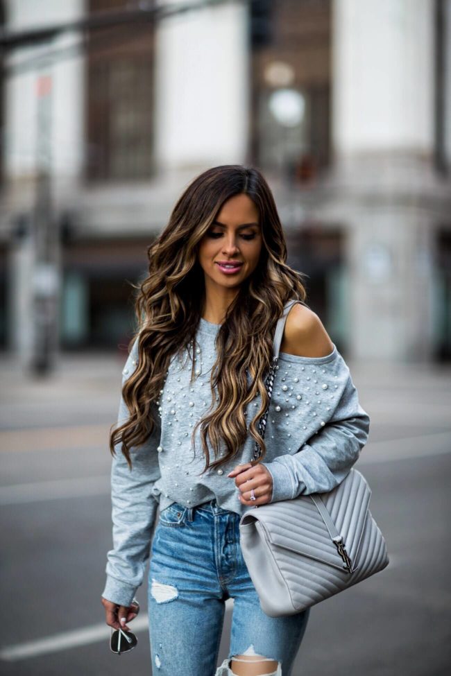 fashion blogger mia mia mine wearing a gray off-shoulder sweatshirt from revolve and grlfrnd denim