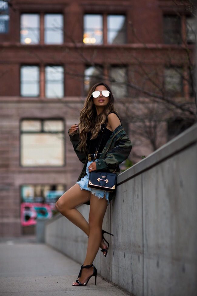 fashion blogger mia mia mine wearing a prada cahier bag and an alpha industries camo jacket