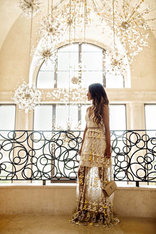 fashion blogger mia mia mine wearing a yellow lace dress at the four seasons orlando resort