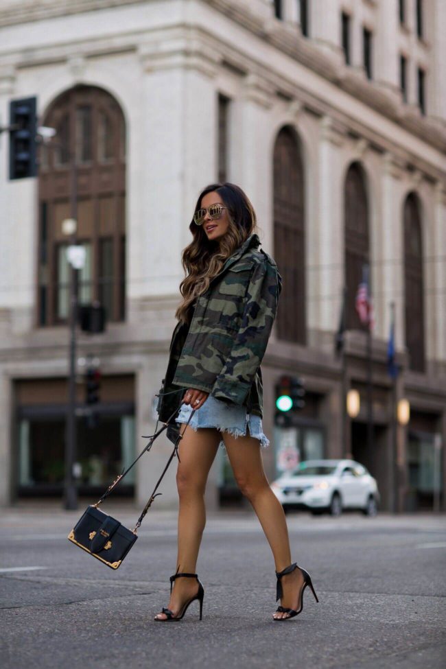 fashion blogger mia mia mine wearing a prada cahier bag and a camo jacket from revolve