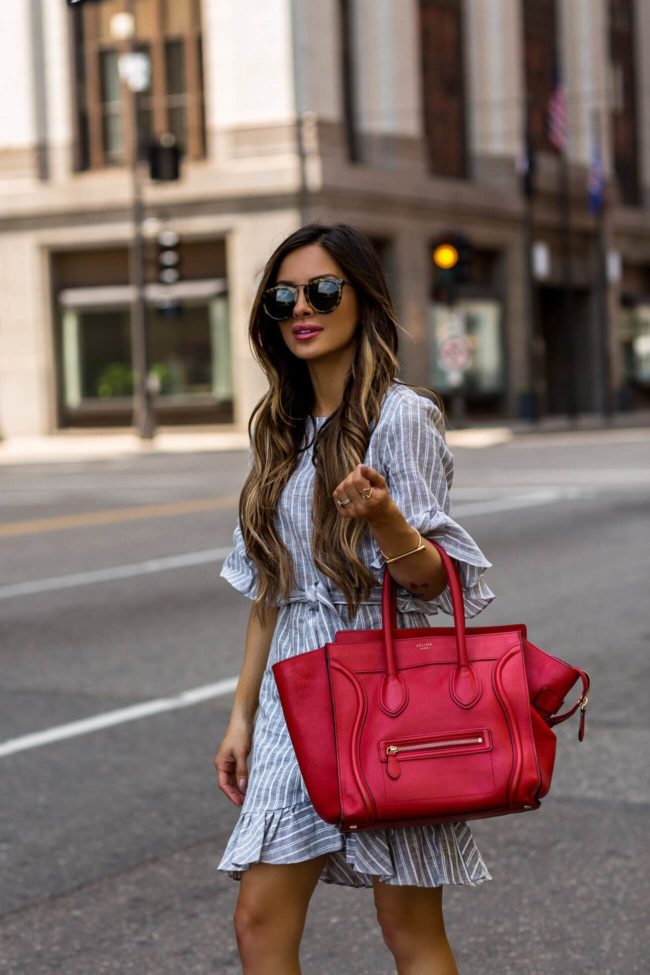 fashion blogger mia mia mine wearing a blue and white striped dress from macy's and a red celine bag