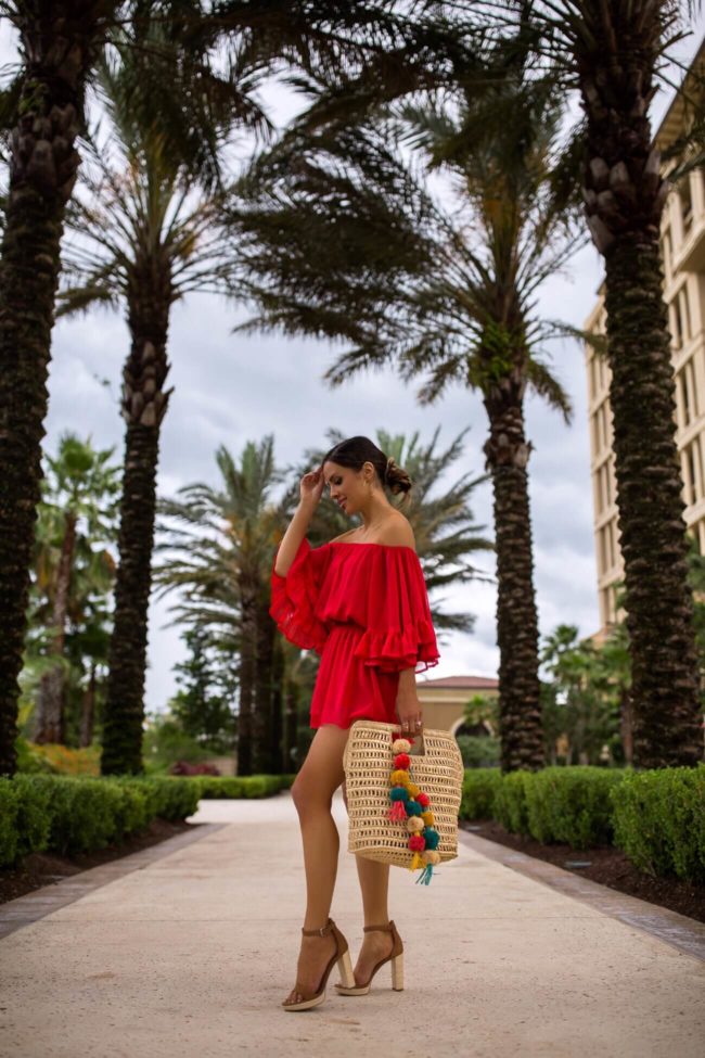 fashion blogger mia mia mine at the four seasons orlando wearing a red romper