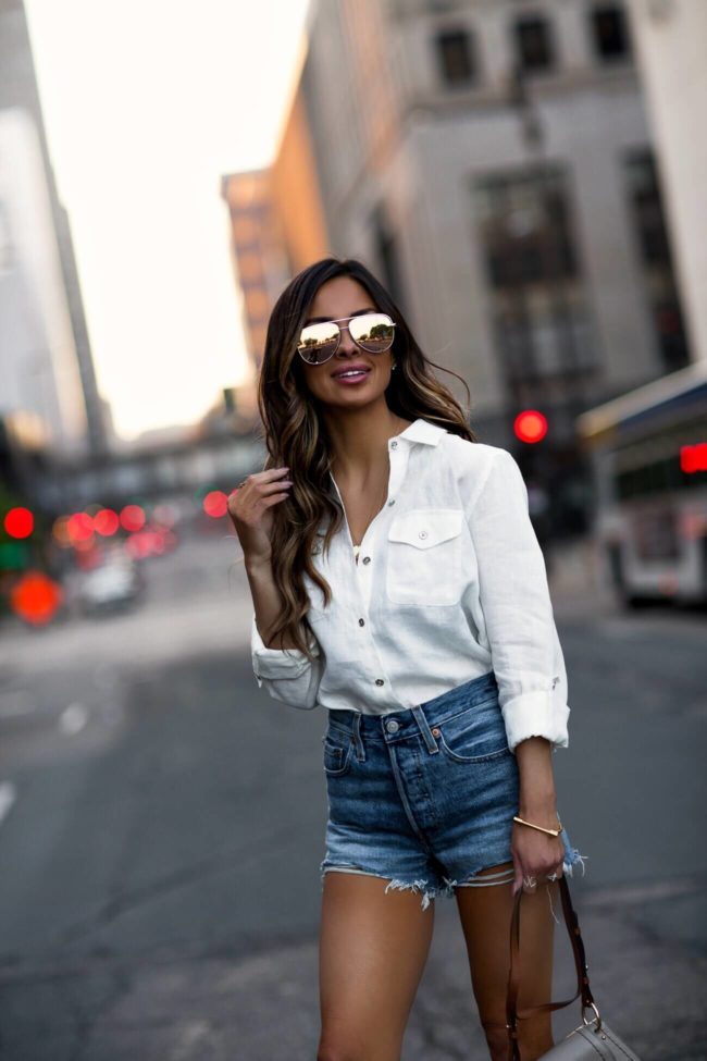 fashion blogger mia mia mine wearing a tommy hilfiger button-down shirt and levi's denim shorts