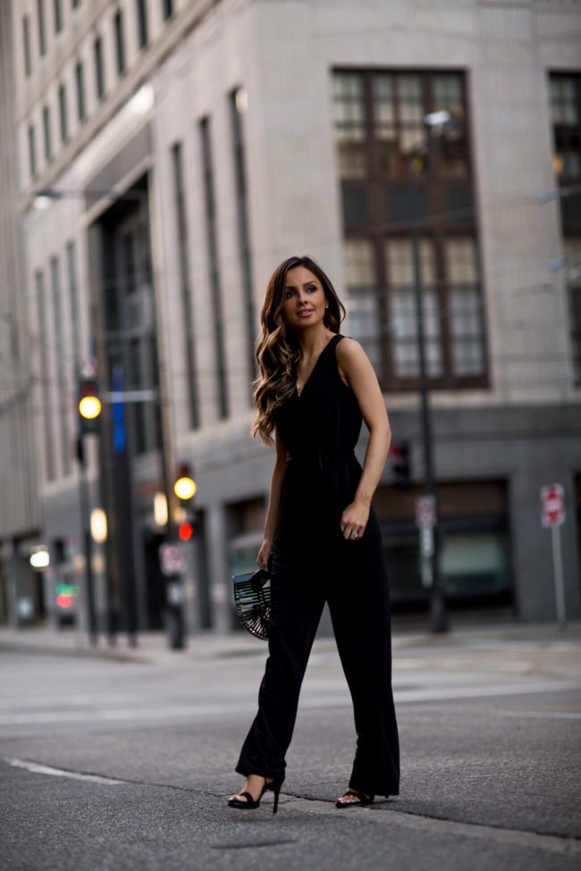 fashion blogger mia mia mine wearing a black petite jumpsuit from macy's